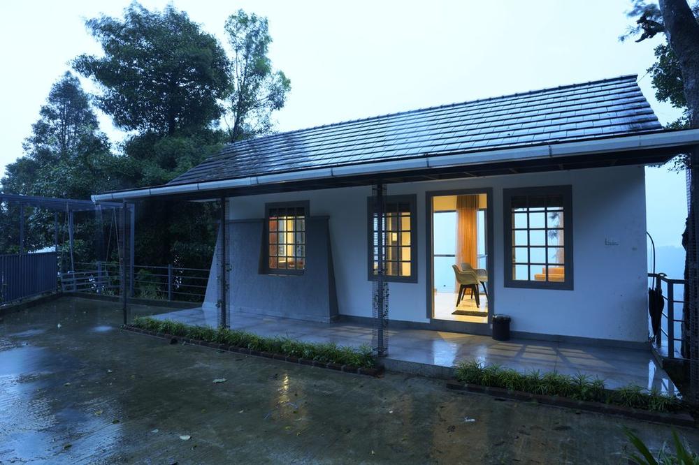 The cottage at dusk with its windows lit